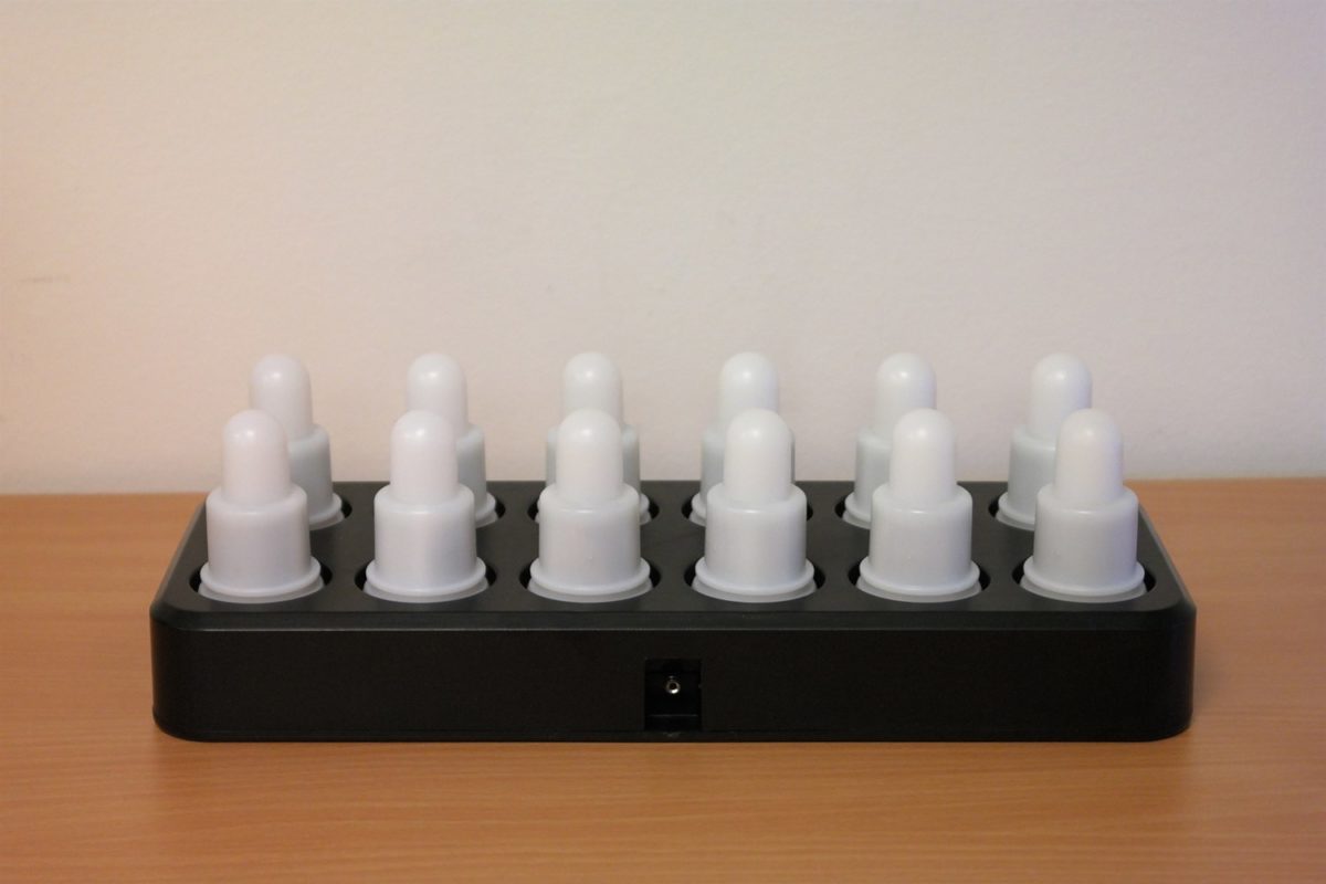 Eight shirts arranged on table in black, olive, grey, blue, white, red, mustard, and green.
