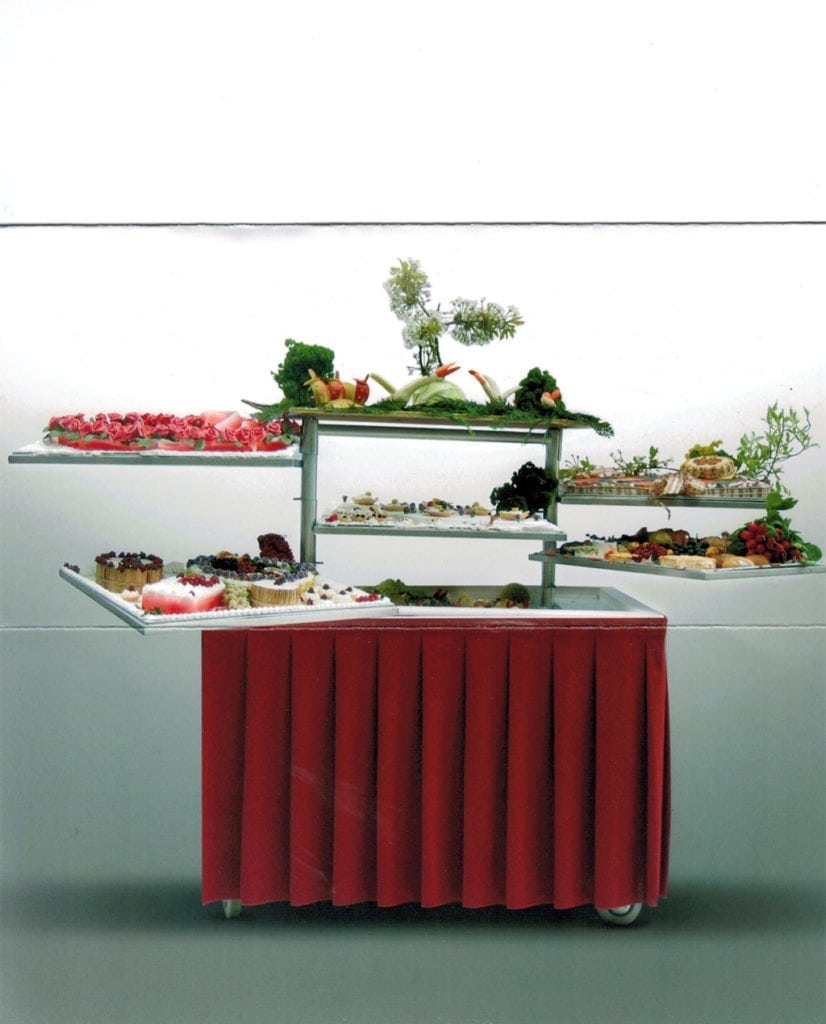 Eight shirts arranged on table in black, olive, grey, blue, white, red, mustard, and green.