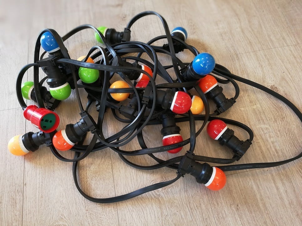 Eight shirts arranged on table in black, olive, grey, blue, white, red, mustard, and green.