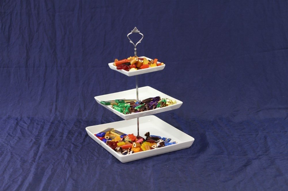 Eight shirts arranged on table in black, olive, grey, blue, white, red, mustard, and green.